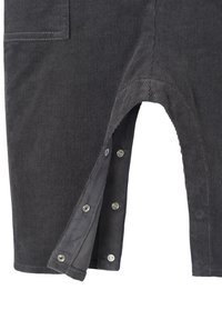 Gray corduroy overalls with a textured surface, featuring a snap closure on the leg opening and a pocket on the front.