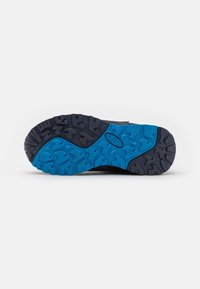 Schwarze Schuhsohle mit einer groben Textur, ausgestattet mit einem blauen Gummibereich und tiefen Profilrillen für Traktion; Mischmaterialien und strapazierfähiges Design.