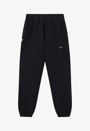 Black sweatpants made of soft material, featuring an elastic waistband, side pockets, and a small gold logo on the thigh.