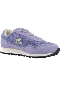 Chaussure de sport violette avec tige en mesh, accents en daim et semelle intermédiaire blanche. Comprend des lacets traditionnels et une semelle extérieure en caoutchouc texturée.