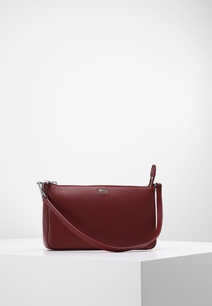 Bordowa skórzana torebka na nadgarstek z srebrnym zamkiem i logo Hugo Boss, umieszczona na białej powierzchni na jasnym, jednolitym tle.