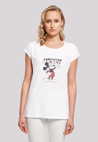 Valge puuvillane t-särk, millel on halli ja punase värviga graafiline print Mickey Mouse'ist, rullitud lühikeste varrukate ja ümmarguse kaelusega disain.