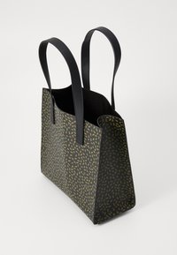 Czarna torba na ramię z zielonym wzorem liści, elegancki design, wyraźny kształt i podwójne czarne uchwyty. Teksturowany materiał zwiększa wizualne zainteresowanie.