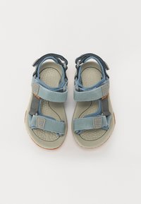 Ljusblå och grå justerbara sandaler med en texturerad fotbädd, robusta remmar och gummiyttersula, designade för komfort och hållbarhet.