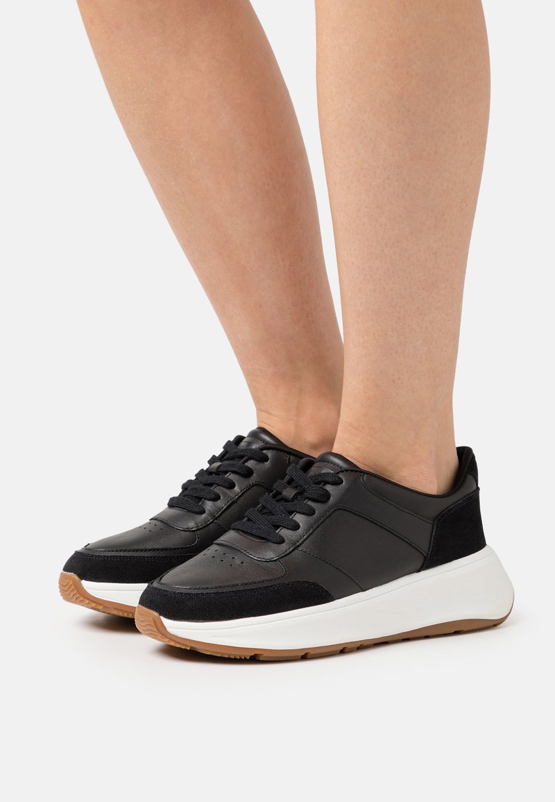 Sorte lærersneakers med suedeforsterkninger, hvit midtsåle og gummigummi yttersåle. Klassisk snøring design med perforerte detaljer.