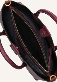 Borsa in pelle bordeaux con zip dorata e interno scuro, dotata di due manici e chiusura a scatto laterale.