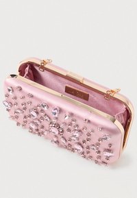 Růžový saténový psaníčko s pozlaceným uzávěrem, zdobené různými velikostmi růžových a průhledných drahokamů, a hedvábnou podšívkou.