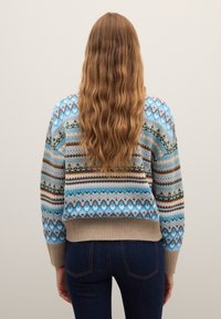 Maglione lavorato a maglia con motivo geometrico in blu, marrone e beige; orlo a coste; vestibilità oversize con maniche lunghe, tessuto strutturato.