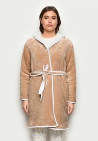 Bata de felpa beige con capucha forrada de lana blanca, ribete blanco en contraste, mangas largas, cinturón de lazo y dos bolsillos frontales.