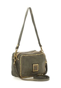 Piccola borsa a tracolla in pelle grigia scura con dettagli in borchie dorate, chiusura con zip, tracolla staccabile e una placca quadrata con il marchio nella parte anteriore.