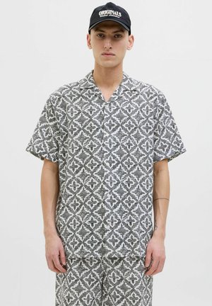 Short-sleeve button-up shirt in black and white with a geometric pattern. Crafted from lightweight fabric, features a notched collar and relaxed fit.