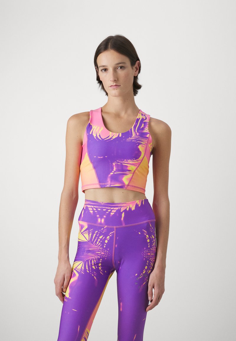 Purple and pink athletic crop top with a round neckline, featuring a vibrant abstract pattern. Paired with matching high-waisted leggings.