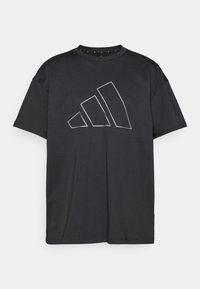 Μαύρο T-shirt από λείο ύφασμα με μεγάλο λευκό περίγραμμα λογοτύπου Adidas. Κοντά μανίκια και στρογγυλή λαιμόκοψη.