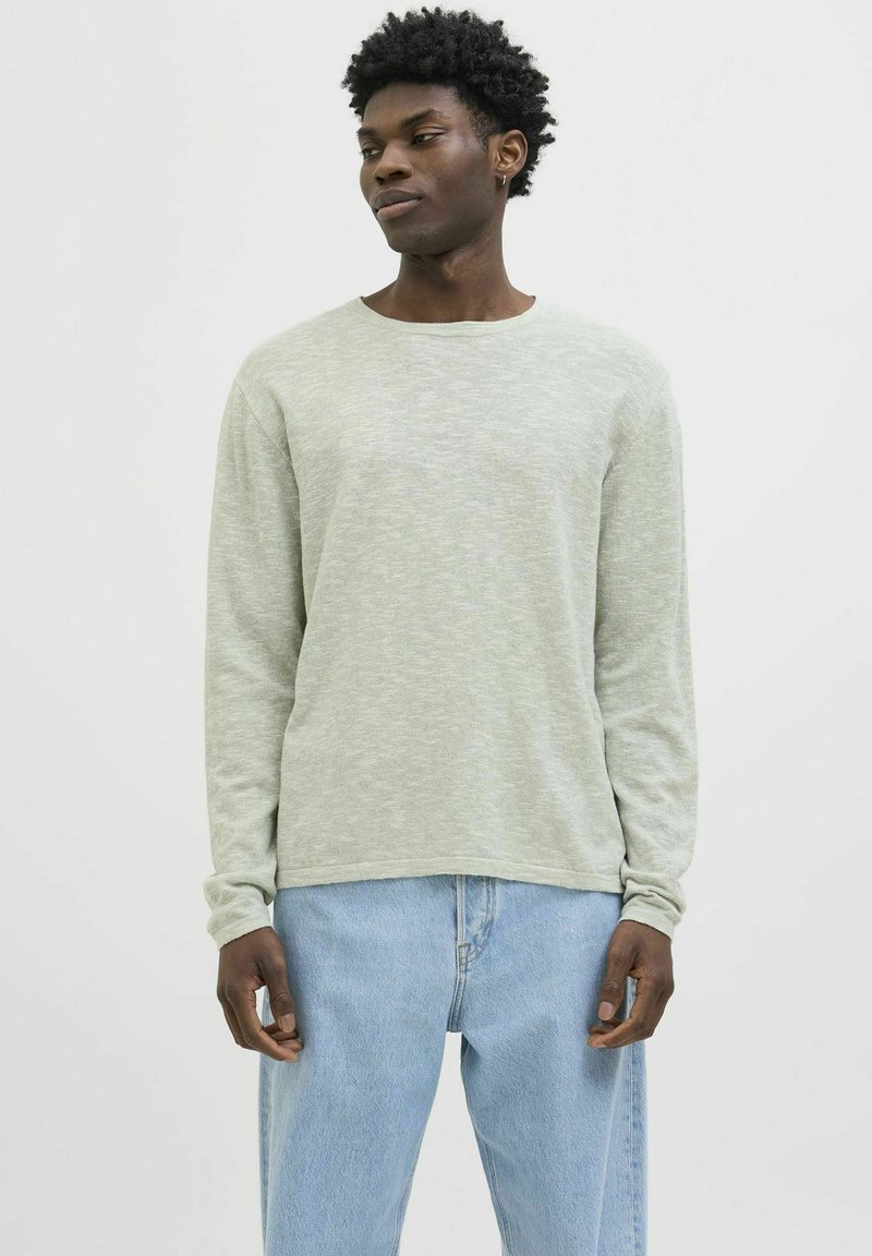 Lange mouwen lichtgroen sweater van een zachte gebreide stof, met een ronde halslijn en een relaxte pasvorm, gecombineerd met lichtblauwe denim jeans.