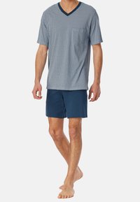 Men's short-sleeve V-neck pajama set, featuring a patterned blue top and solid navy shorts, made from soft fabric for comfort.