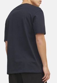 Mørkeblå kortærmet t-shirt lavet af blød bomuld, med rund hals og afslappet pasform, samt en glat overflade og minimalistisk design.