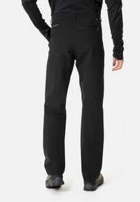 Pantaloni da esterno neri, tessuti, con taglio dritto, dotati di una tasca con zip sul retro e cuciture distinte sul ginocchio per una maggiore mobilità.