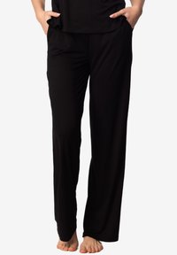 Czarne spodnie wykonane z miękkiego materiału, o luźnym kroju, szerokich nogawkach i kieszeniach, z gładką teksturą i bez widocznych wzorów.