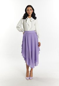 Witte blouse met een grote strik, gelaagde lila rok, gladde textuur, gerafelde randen en bijpassende lila hakken. Eenvoudig, elegant ontwerp.