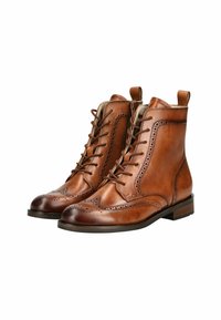 Stivali in pelle marrone con lacci, dettagli brogue, punta arrotondata e tacco basso. Presentano un linguetta di estrazione e cuciture a contrasto.