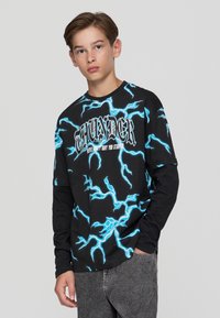 Czarna koszulka z długim rękawem z dużymi niebieskimi wzorami błyskawic oraz napisem "THUNDER" na przodzie; luźny fason z okrągłym dekoltem.