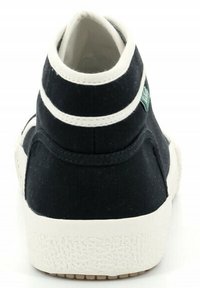 Sneaker nera alta con accenti bianchi, suola in gomma testurizzata, punta tondeggiante e colletto imbottito. Presenta un piccolo emblema verde sul lato.