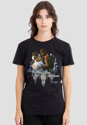 Young woman wears black tee with masked couple dancing surrounded by flowers and text "Every Love Story is Different" from Bridgerton.