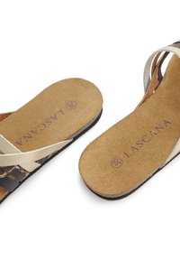 Brown and beige sandals with a suede insole and dual straps. The insole features the brand name "LASCANA" in purple. Flat sole design.