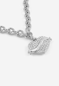 Collana in argento con pendente a forma di cuore decorato con strass trasparenti, che presenta una finitura liscia e lucida e un design curvo.