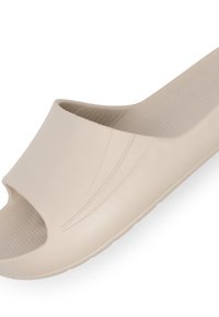 Lys beige slide sandal lavet af glat plastik. Åben tå design med en bred rem og subtile teksturerede detaljerne på sålen.