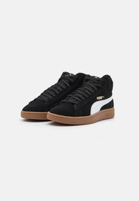 Černé semišové vysoké tenisky s bílým logem, černými tkaničkami a hnědou gumovou podrážkou. Obsahují polstrovaný límec pro větší pohodlí.