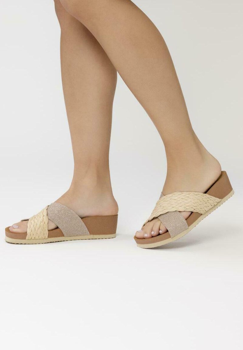 Sandales à semelle tissée présentant un dessus tissé beige et une base brune avec une finition texturée. La semelle a une légère plateforme pour un peu d'élévation.