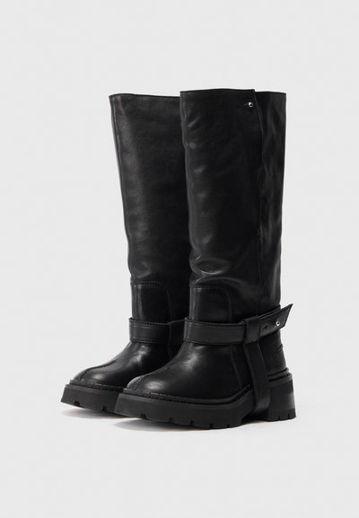 Μαύρες γόβες μέχρι το γόνατο από δέρμα, με παχιά ελαστική σόλα, φαρδιές λωρίδες γύρω από τον αστράγαλο και ελαφρώς υφή.