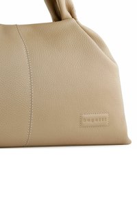 Beige Lederhandtasche mit strukturiertem Finish, ausgestattet mit kontrastierenden Nähten und einem dezenten geprägten Logo. Geschwungene Silhouette mit kurzen Griffen.