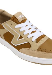 Beige og brun sneakers med teksturert stoff og lær, hvite snørebånd og en mønstret tå. Har logo på tungen og design på siden.