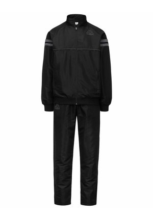 Tuta nera composta da una giacca con colletto alto e zip, e pantaloni coordinati. Caratterizzata da strisce riflettenti e dettagli con logo.