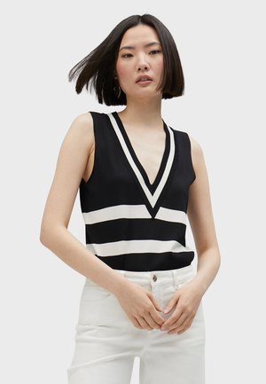 Black and white striped sleeveless top with a deep V-neck design, made from a smooth fabric. Worn with white high-waisted pants.