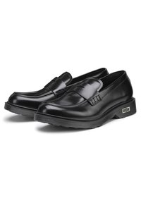 Zwarte leren instappers met een soepele afwerking, voorzien van een decoratieve band en stiksels. Weerstands rubberen zool voor extra grip.