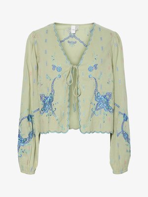 Light green cropped blouse with long sleeves, blue floral embroidery, scalloped edges, and front tie closure.