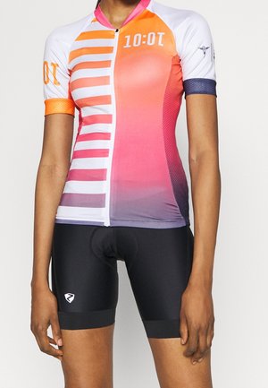 Atleet draagt een roze, oranje en wit fietsjersey met rits aan de voorkant en zwarte fietsbroekjes tegen een effen achtergrond.