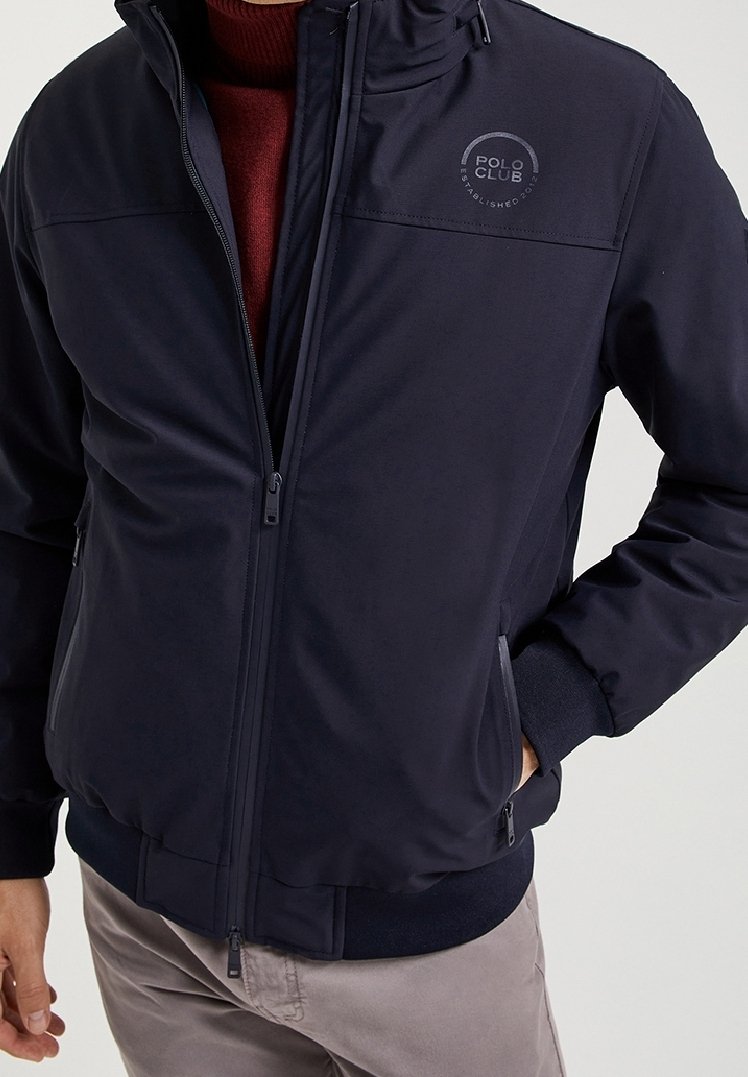 Navy blue zip-up jacket made of smooth fabric, featuring a round logo on the left chest, side pockets, and elastic cuffs.