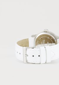 Cinturino in pelle bianca con fibbia in argento, caratterizzato da una superficie liscia e cinque fori di regolazione, montato su una cassa orologio metallica.