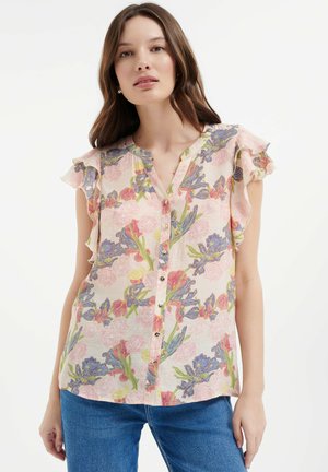 Blusa floreale con maniche a volant, in tessuto rosa pastello con motivi floreali blu e verdi e chiusura anteriore con bottoni.