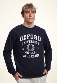 Navyblauwe sweatshirt van katoen, met witte bedrukte tekst "OXFORD UNIVERSITY" en laurierontwerp, ronde hals, ribgebreide manchetten en onderrand.