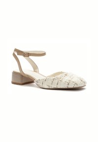 Flat-heeled shoe in textured white fabric with a beige ankle strap. Rounded toe and sturdy block heel with a horizontal striped pattern.
