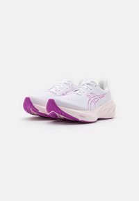 Weiße Sportschuhe mit einer strukturierten Mesh-Oberfläche, rosa Akzenten und einer dicken Sohle mit einer gemusterten lila Laufsohle.
