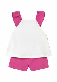 Top bianco senza maniche con spalline arricciate rosa e pantaloni corti rosa abbinati. Realizzato in morbido cotone, adatto per il clima caldo.