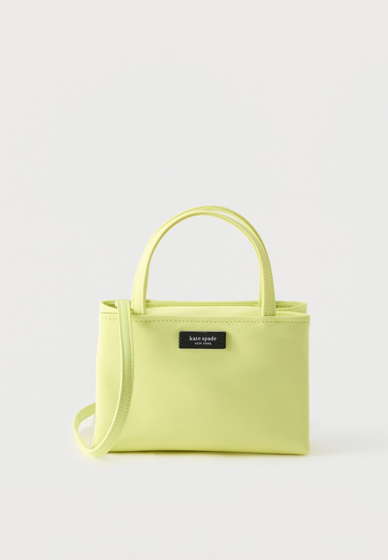 Μικρό ορθογώνιο τσάντα χειρός ανοιχτού πράσινου χρώματος με δύο λαβές και αποσπώμενο ιμάντα ώμου σε απλό φόντο.