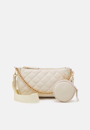 Cremefarbene gesteppte Handtasche mit goldener Kette, verstellbarem Stoffriemen und angebrachtem rundem Münzbeutel mit Reißverschluss.