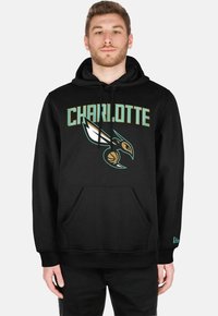 Black hoodie featuring "CHARLOTTE" in bold letters above a stylized bird logo. Made of soft fabric, with a front pocket and adjustable hood.
